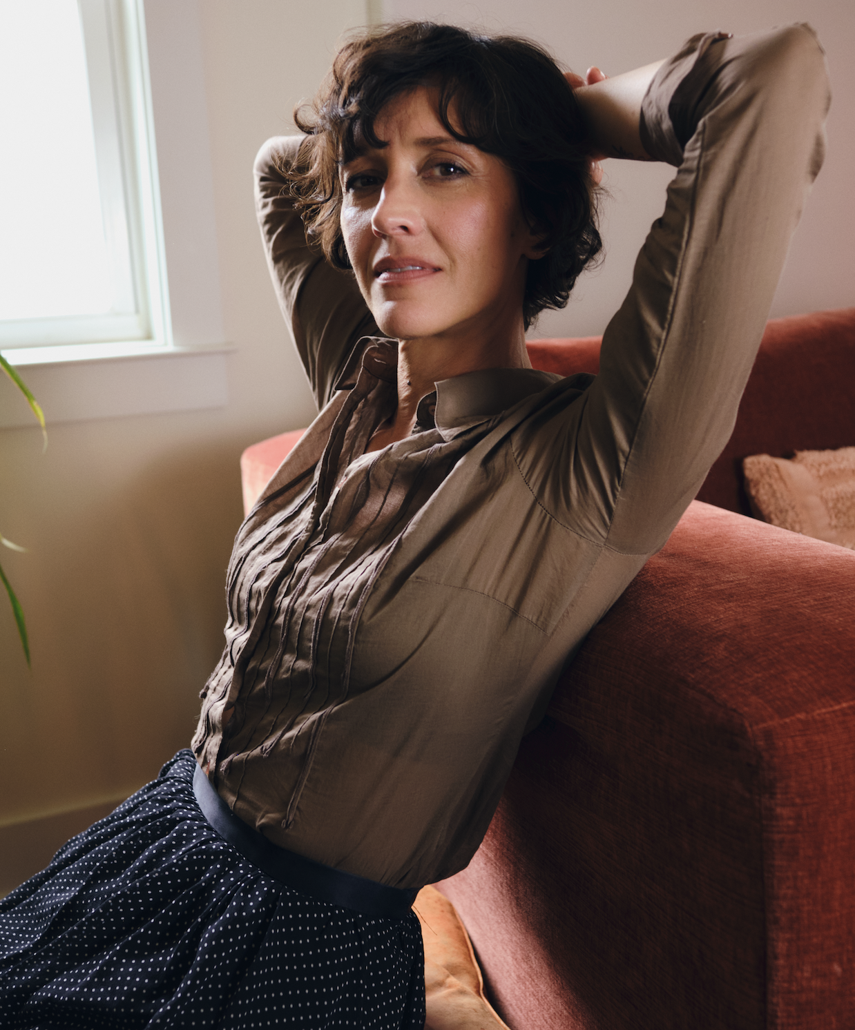 Christa Wells sitting in a sunlit room, relaxed and looking at camera with a soft smile